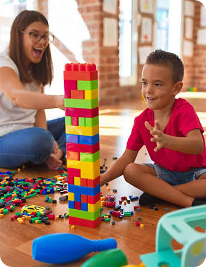 Child and parent building a block tower together